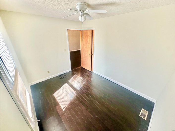 Unfurnished room featuring ceiling fan, a textured ceiling, and dark hardwood / wood-style flooring