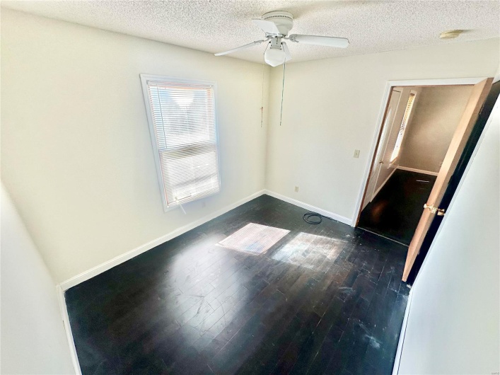 Unfurnished room featuring ceiling fan, a textured ceiling, and dark hardwood / wood-style floors