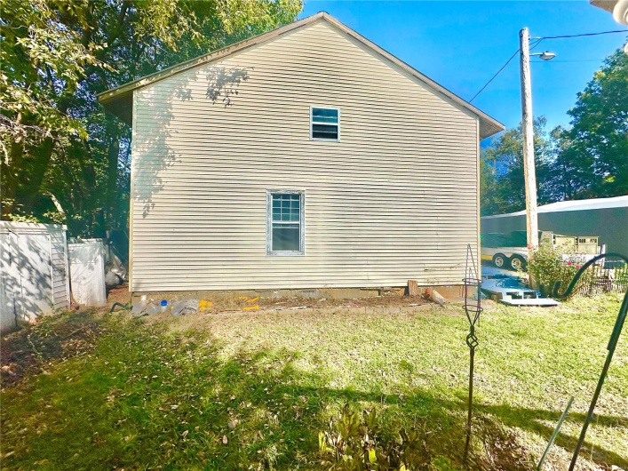 View of side of property featuring a lawn