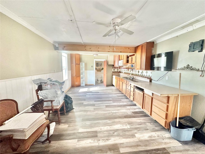 Kitchen featuring ceiling fan, decorative backsplash, and light hardwood / wood-style flooring
