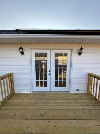 View of exterior entry featuring a wooden deck