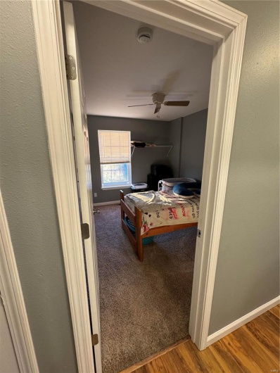 Bedroom with ceiling fan and hardwood / wood-style flooring