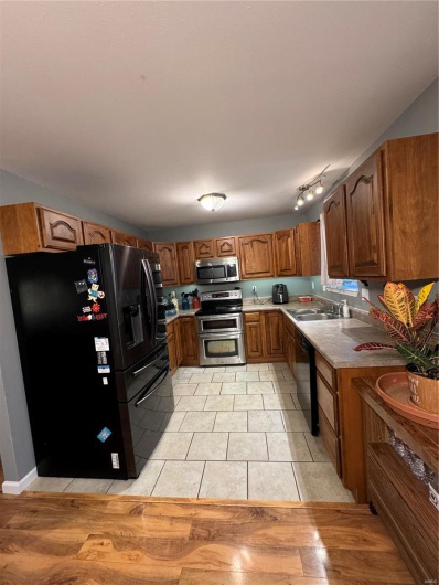 Kitchen featuring appliances with stainless steel finishes, light tile patterned floors, and sink