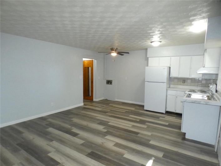 Kitchen featuring ceiling fan, white cabinets, stove, dark wood-type flooring, and white fridge