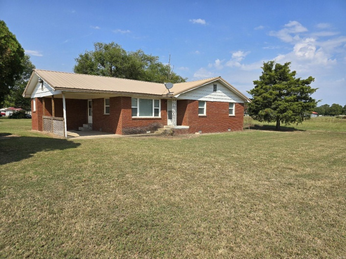 Single story home with a front lawn and a patio area