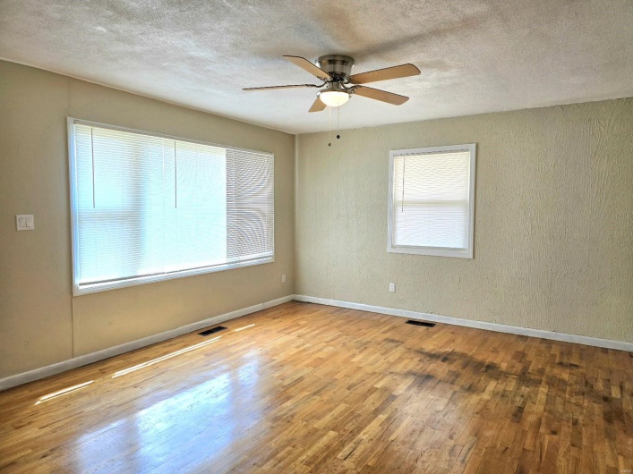 Unfurnished room featuring light hardwood / wood-style flooring, a textured ceiling, and ceiling fan