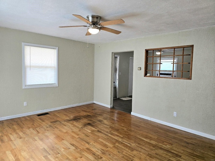 Unfurnished room with ceiling fan, a textured ceiling, and hardwood / wood-style floors