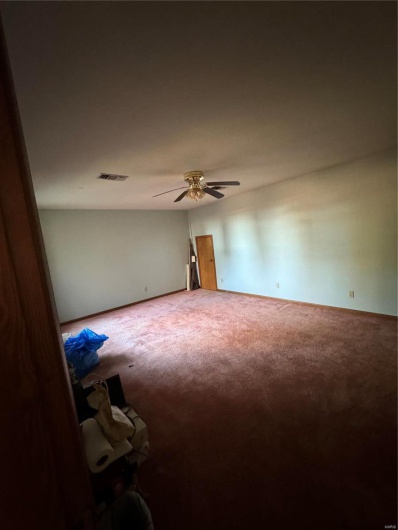 Unfurnished room with ceiling fan and carpet flooring