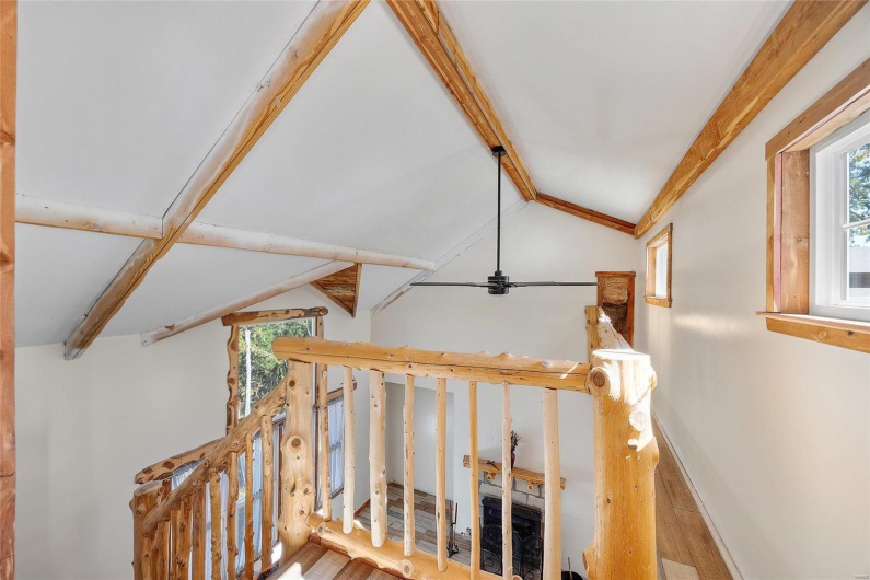 view of vaulted ceilings at top of stairs 