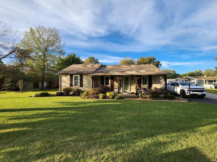 Ranch-style home featuring a porch and a front yard