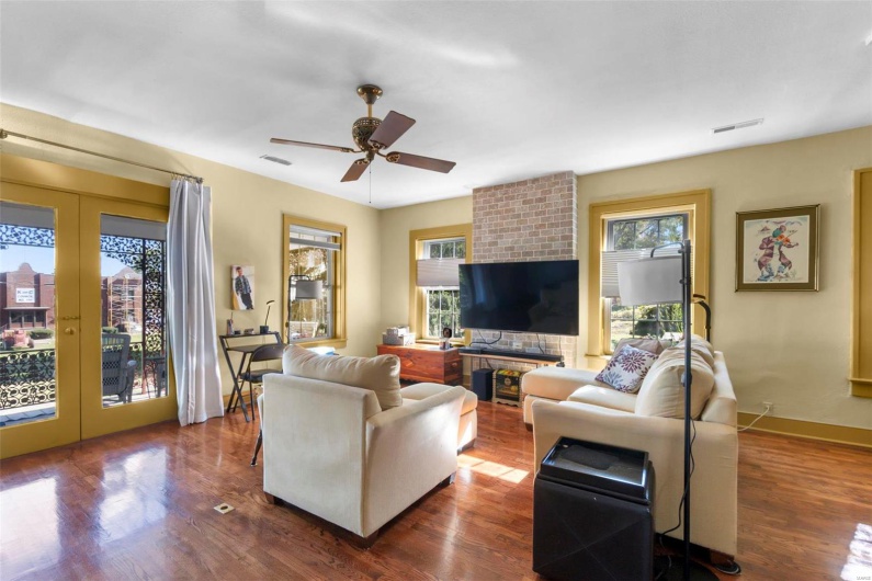 Living room featuring ceiling fan, a healthy amount of sunlight, and dark hardwood / wood-style flooring