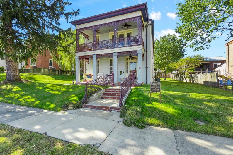 View of front of property with covered porch, ceiling fan, and a front lawn