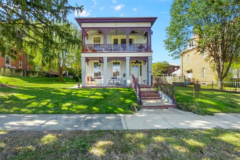 View of front of home with a front lawn, covered porch, and ceiling fan