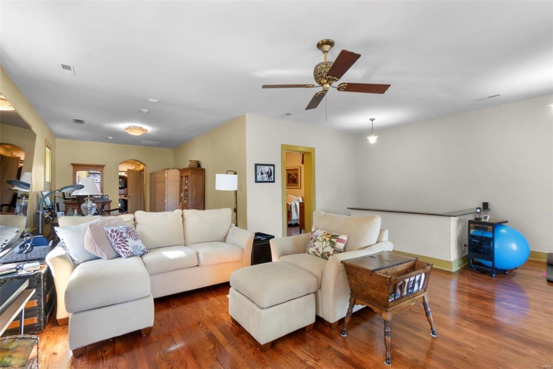 Living room with dark hardwood / wood-style floors and ceiling fan