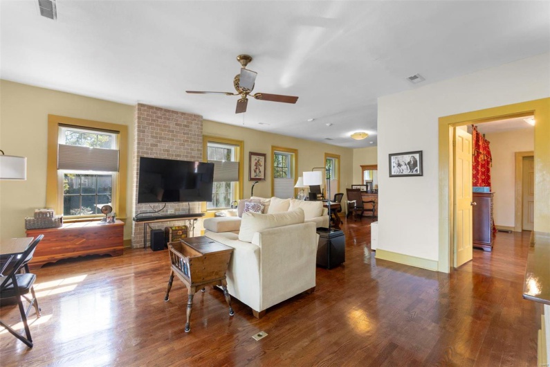 Living room with ceiling fan and dark hardwood / wood-style flooring
