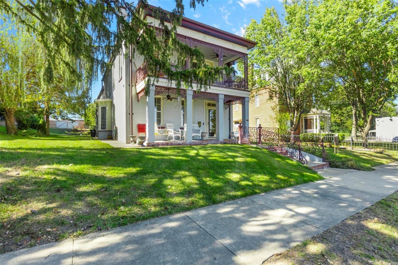 View of front of house featuring ceiling fan and a front lawn