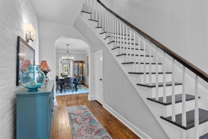 Stairs featuring ornamental molding, a chandelier, and hardwood / wood-style floors