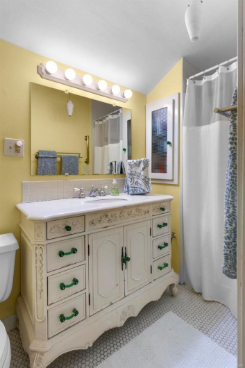 Bathroom with vanity, toilet, tile patterned flooring, and a shower with shower curtain