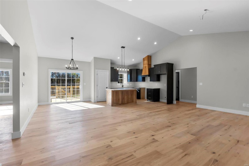 Kitchen with a healthy amount of sunlight, a kitchen island, and light hardwood / wood-style flooring