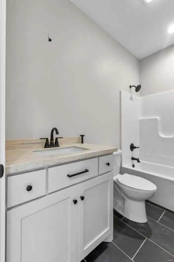 Full bathroom with shower / tub combination, tile patterned flooring, vanity, and toilet