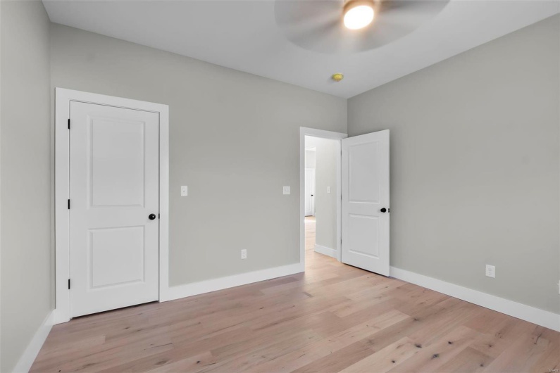 Unfurnished bedroom with ceiling fan and light hardwood / wood-style flooring