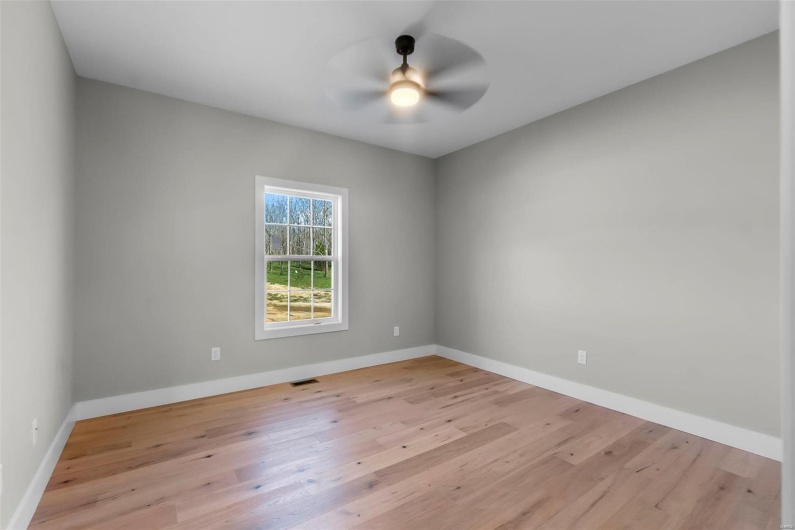Empty room with ceiling fan and light wood-type flooring