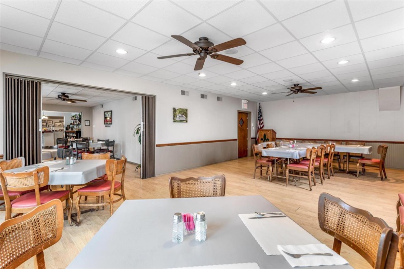 Dining area featuring light hardwood / wood-style floors, a drop ceiling, and ceiling fan