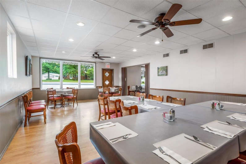 Dining space with light hardwood / wood-style floors, a drop ceiling, and ceiling fan