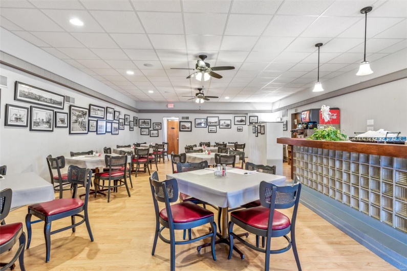 Dining room with light hardwood / wood-style flooring, a paneled ceiling, and ceiling fan