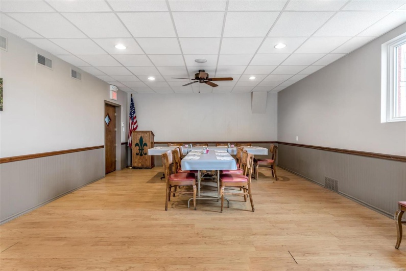 Dining room featuring light hardwood / wood-style floors, a drop ceiling, and ceiling fan