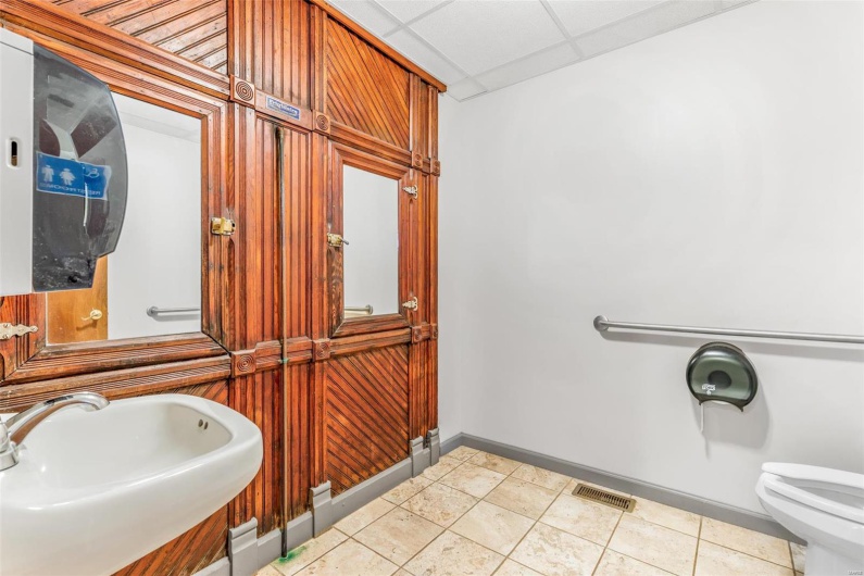 Bathroom with toilet, a paneled ceiling, sink, and tile patterned flooring