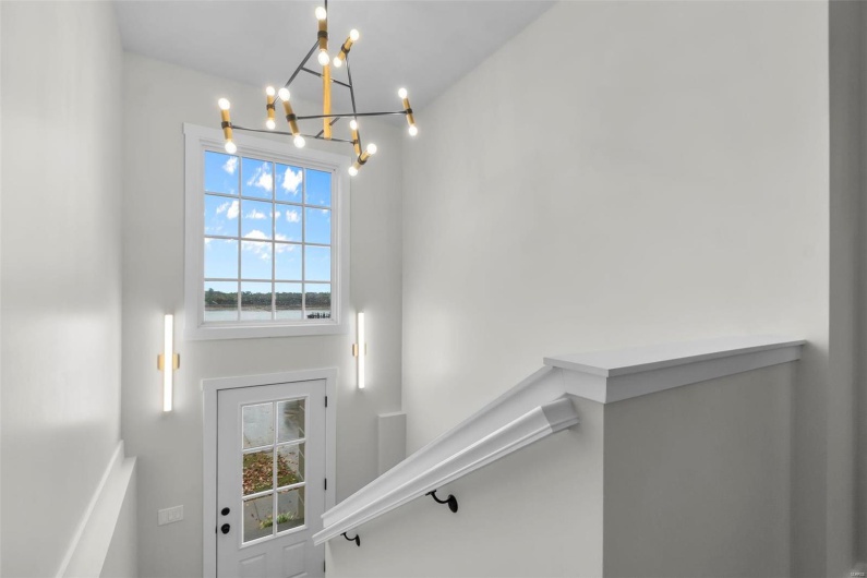 Stairs featuring a notable chandelier
