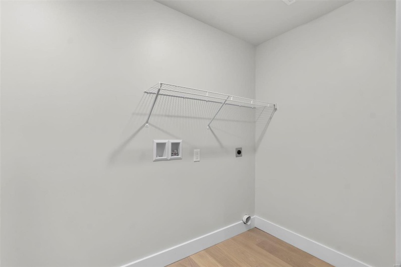 Clothes washing area with electric dryer hookup, wood-type flooring, and washer hookup