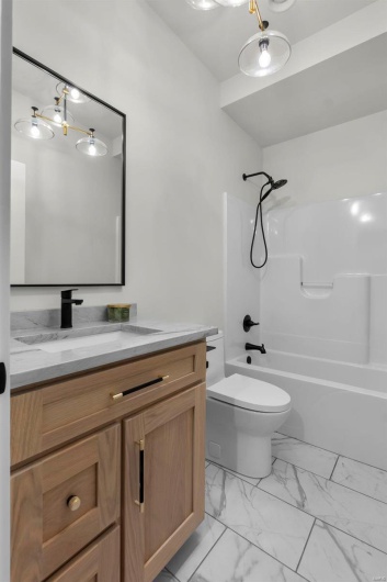 Full bathroom with vanity, bathtub / shower combination, and toilet