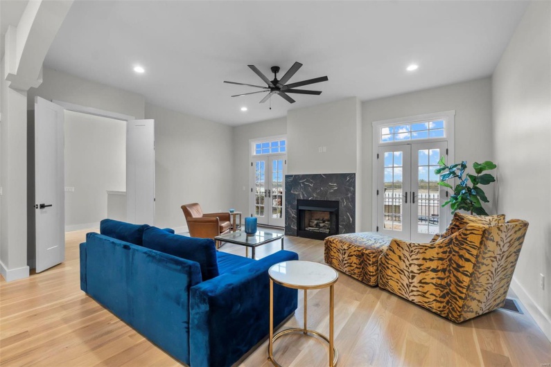 Living room featuring french doors, light hardwood / wood-style flooring, a wealth of natural light, and ceiling fan