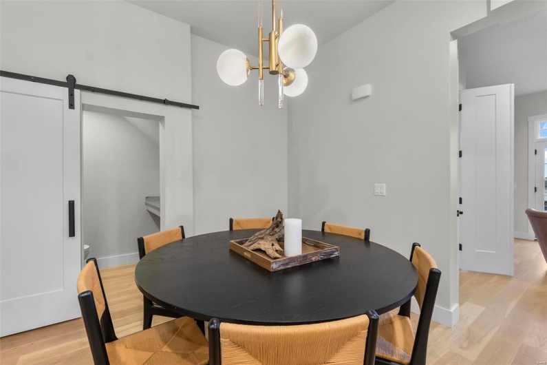 Dining space featuring a chandelier, light wood-type flooring, and a barn door