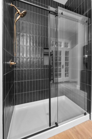 Bathroom with hardwood / wood-style floors and an enclosed shower