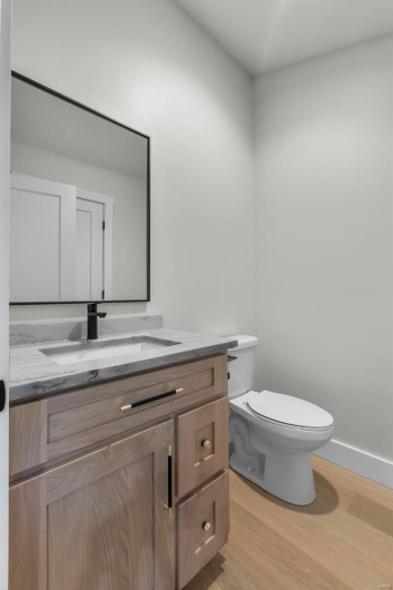 Bathroom with vanity, hardwood / wood-style floors, and toilet