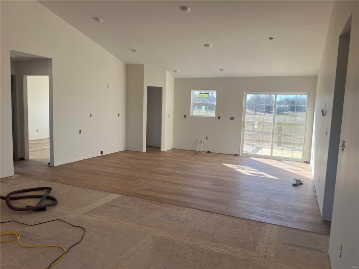 Unfurnished living room featuring light hardwood / wood-style floors and vaulted ceiling