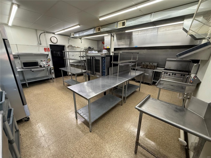 Kitchen with tile patterned floors, appliances with stainless steel finishes, and visible vents
