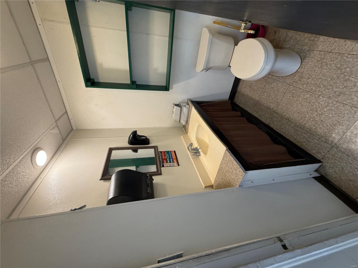 Bathroom featuring toilet, vanity, baseboards, and a drop ceiling