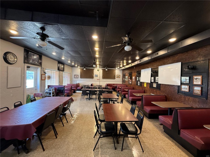 Carpeted dining room with a ceiling fan