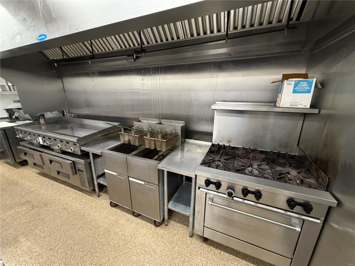 Kitchen with stainless steel stove and light floors