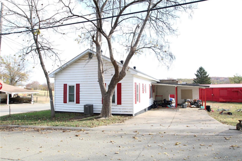 View of side of home with cooling unit and a carport