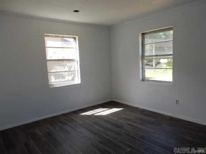 Empty room featuring a wealth of natural light and dark hardwood / wood-style floors