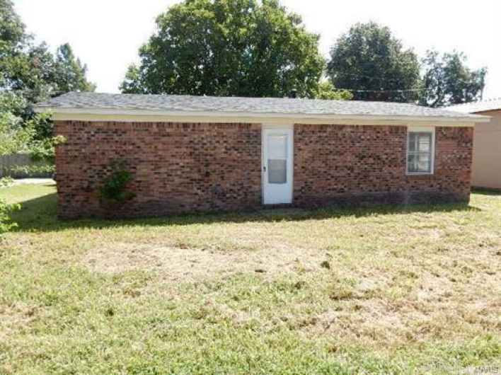 Back of property with a lawn
