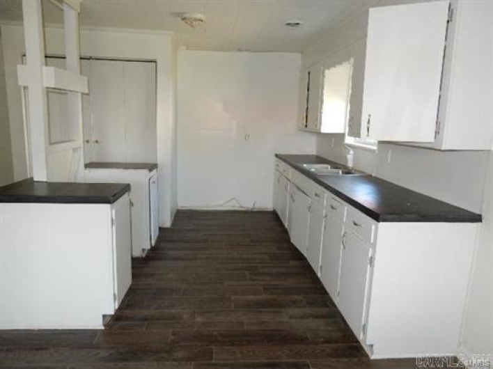 Kitchen with sink, dark hardwood / wood-style flooring, and white cabinets