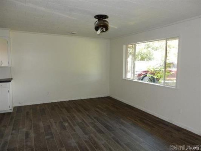 Empty room featuring ornamental molding and dark wood-type flooring