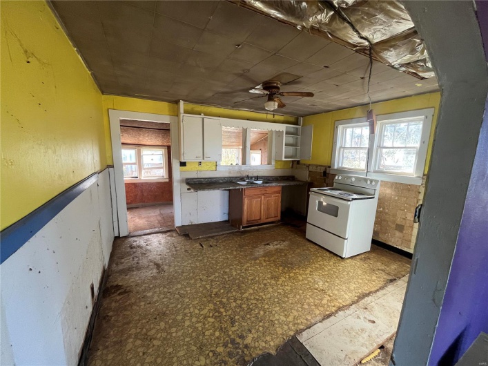 Kitchen featuring a wealth of natural light, ceiling fan, sink, and electric stove