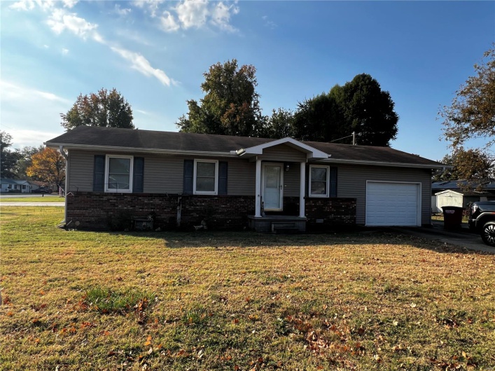 Ranch-style home with a garage and a front lawn